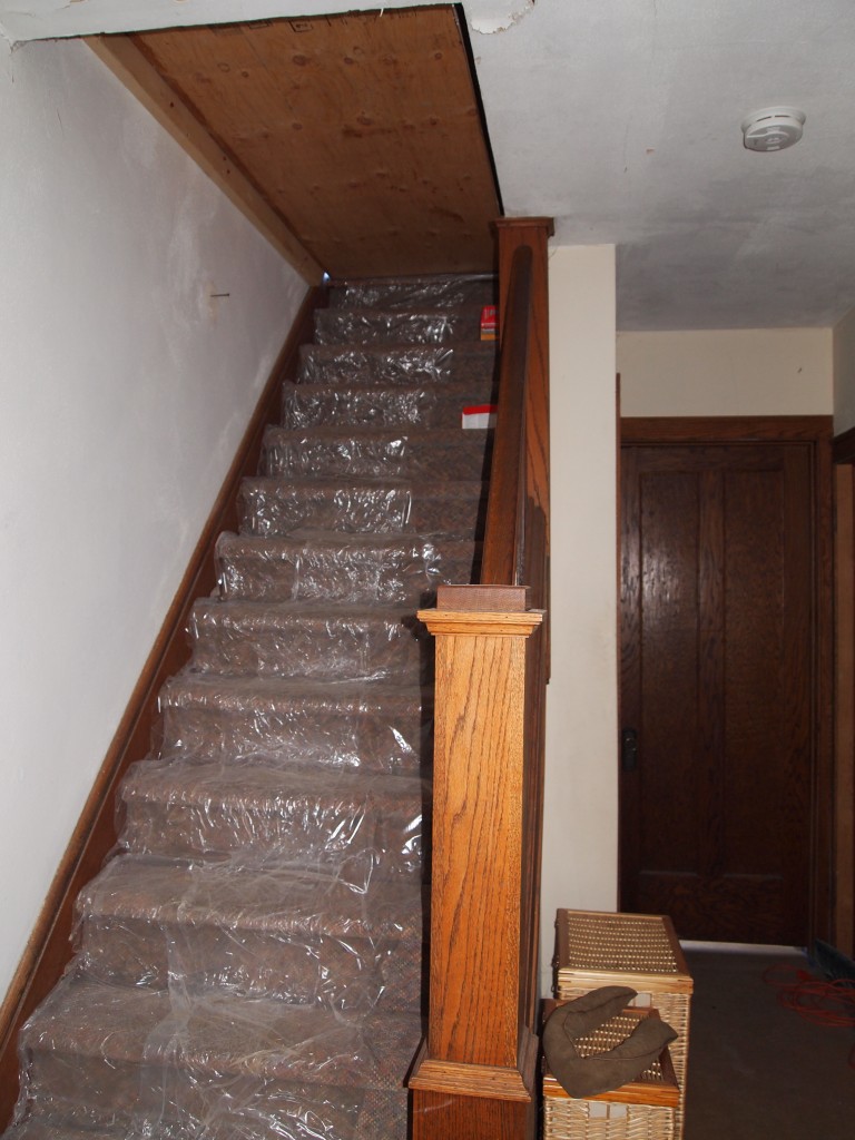 Stairway to the second floor blocked to provide a surface to walk on and to somewhat block the cold air. The plastic is to protect the carpet. 