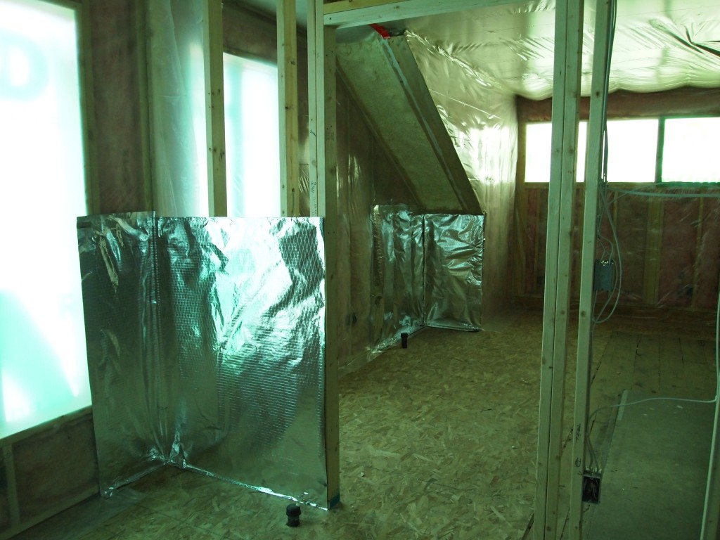 Foil is placed on top of the insulation in the areas where the radiators will be. The heat will be reflected back into the rooms.