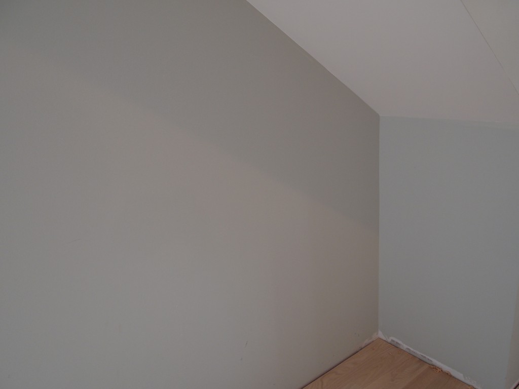 The upstairs paint color looks different in different lighting conditions. The shadow is cast by the angled ceiling from an incandescent light.