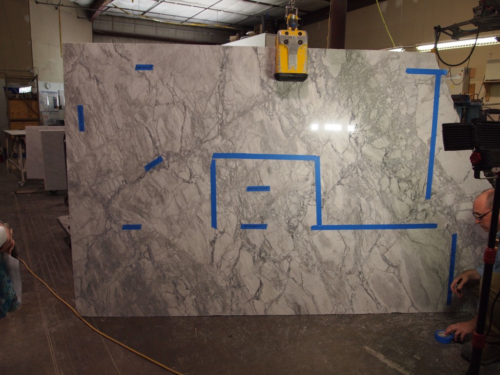 Quartzite slab from which the countertops will be made. The blue tape marks out the sink and other cutting information.