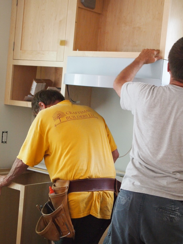 Mike and Rick install the range hood.