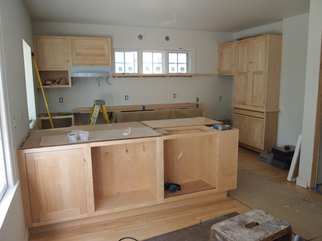 The cabinets and range hood are in. Still a lot of work ahead.