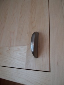 Close up of small pull on a cabinet door.