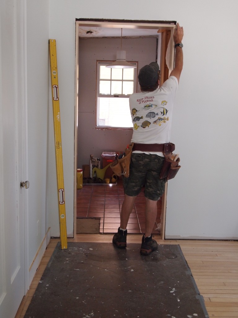 Door jamb and casing being installed. Note that the baseboard, cap, and shoe need to be finished.